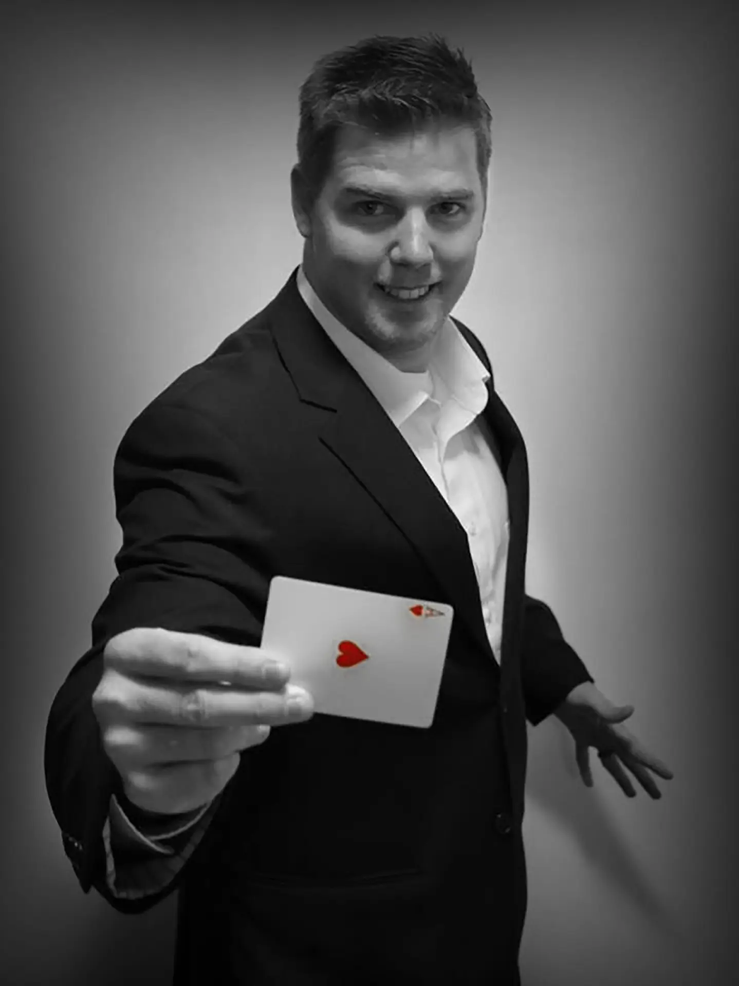 Brady Ramsey holding an Ace of Hearts playing card, ready to perform and astound the guests